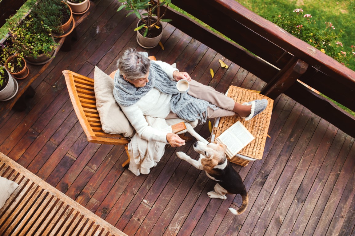 Woman relaxing on her deck with her dog